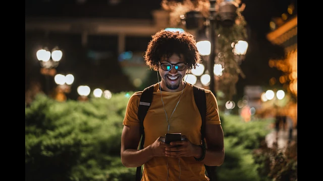 Student smiles at his phone during the night 
